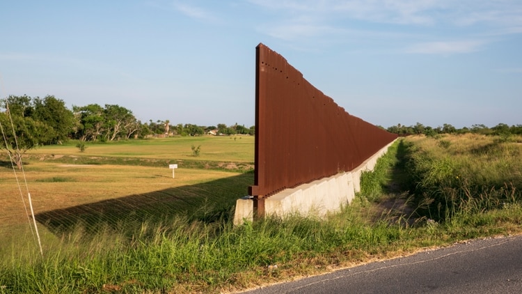 Una interrupción en el cercado fronterizo permite el paso de una calle en Brownsville, Texas. (Ilana Panich-Linsman para The New York Times)