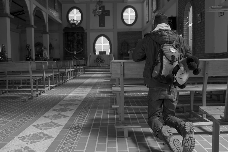 Héctor reza en una iglesia cerca del páramo de Berlín, Colombia. Fotógrafo: Carlos Villalon / Bloomberg.
