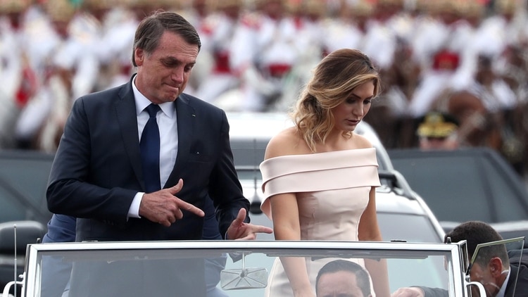 Jair Bolsonaro realiza su ademán característico simbolizando un arma al arribar a la ceremonia de asunción junto a su esposa Michelle (Foto: Reuters)