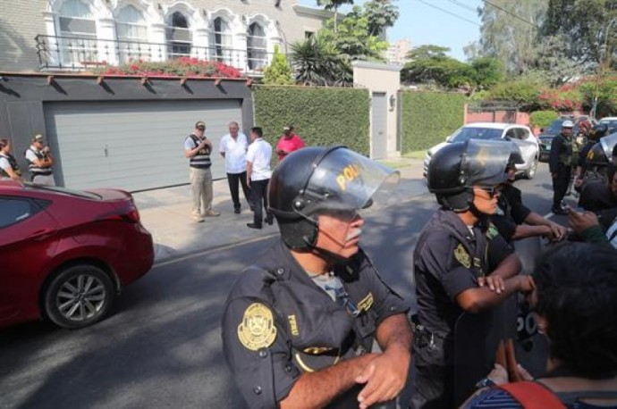 Policías esperan fuera de la casa del ex presidente de Perú, Pedro Pablo Kuczynski, para su detención. FOTO: EFE