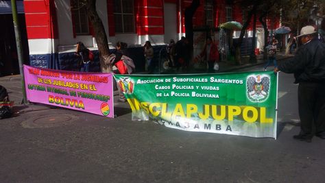 Un jubilado instala una pancarta en medio de la avenida 16 de Julio de La Paz.