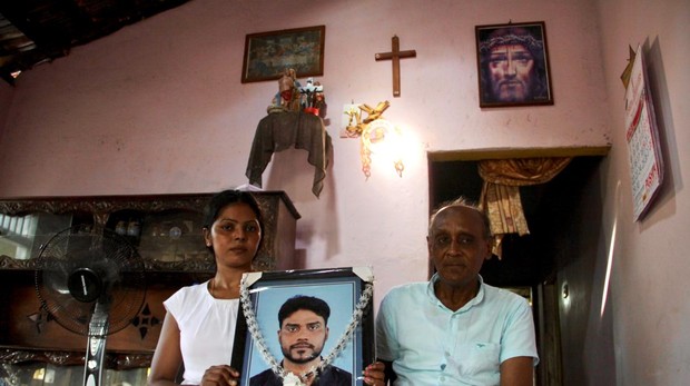 Patrick Fernando sostiene el retrato de su hijo, Marians Niranjan, junto a su viuda, Rupaseeli Kumari, que se salvó de milagro del atentado en la iglesia de San Sebastián en Negombo