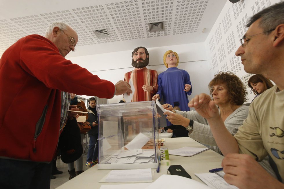 Un hombre introduce su voto en una de las urnas en el Casal de barri Sant Pere de Terrasa.