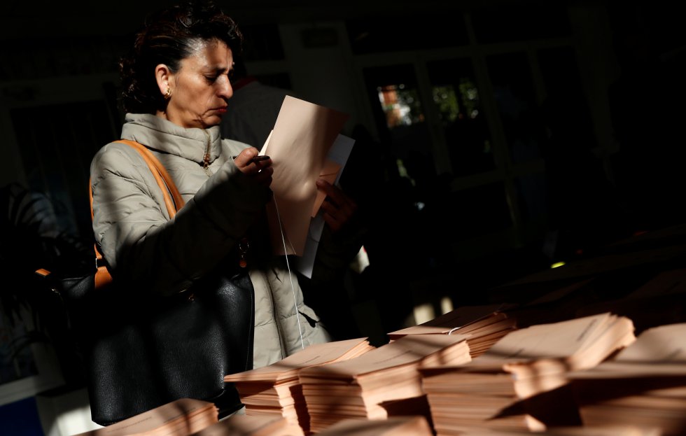 Los colegios electorales han abierto sus puertas a las 09:00 para recoger el voto de los casi 36,9 millones de electores. En la imagen, una mujer selecciona una papeleta en un centro cultural de Madrid.