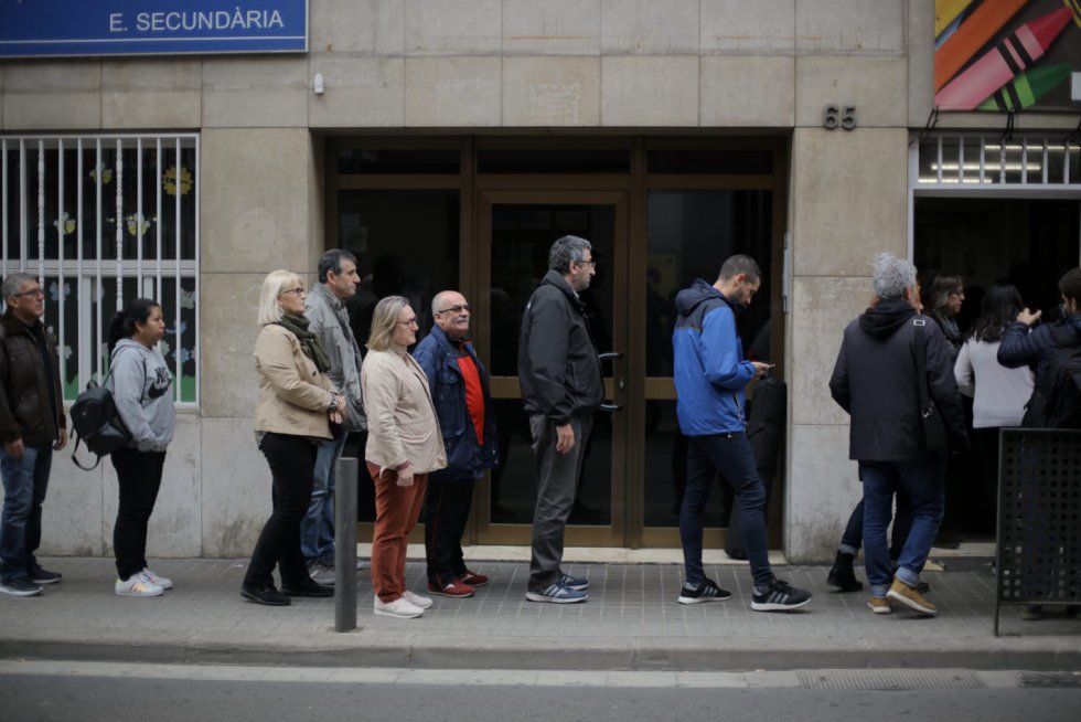 Votantes hacen cola para votar en el colegio Santa Marta de Hospitalet de Llobregat.