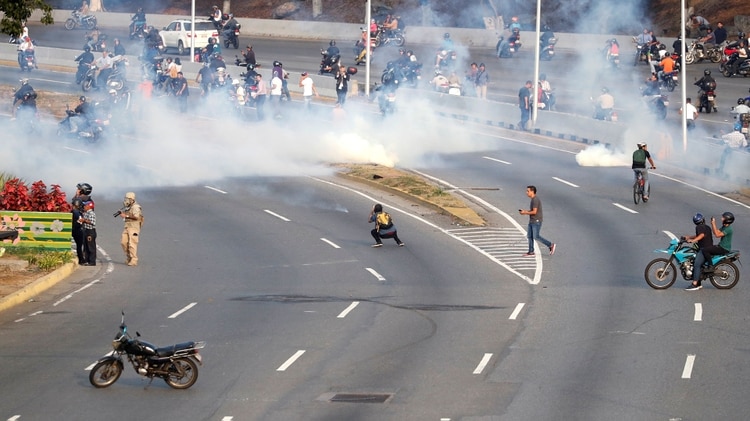 La gente huye de los gases lacrimógenos lanzados por las fuerzas chavistas. REUTERS/Carlos Garcia Rawlins