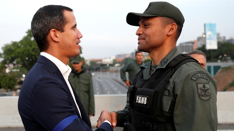 El líder de la oposición venezolana Juan Guaido da la mano a un militar cerca de la Base Aérea “La Carlota” del Generalísimo Francisco de Miranda, en Caracas, Venezuela, el 30 de abril de 2019. (REUTERS/Carlos Garcia Rawlins)