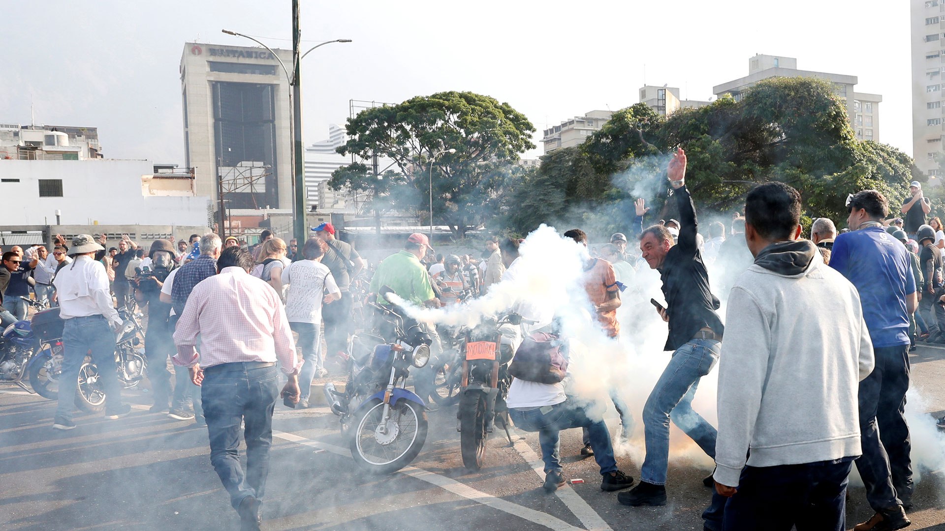 La gente reacciona al gas lacrimÃ³geno cerca de la Base AÃ©rea GeneralÃ­simo Francisco de Miranda âLa Carlotaâ, en Caracas, Venezuela, el 30 de abril de 2019.