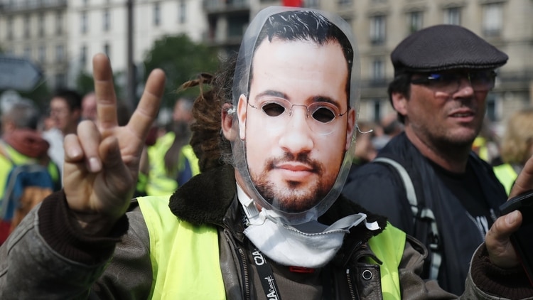 Un manifestante, con una careta de Alexandre Benalla, ex guardaespaldas de Macron despedido por reprimir irregularmente en una protesta (Zakaria ABDELKAFI / AFP)
