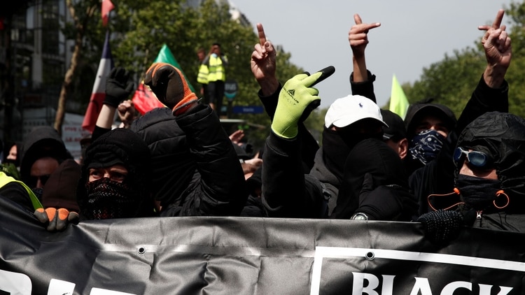 Manifestantes enmascarados asisten a una manifestación durante el tradicional día del trabajo del Primero de Mayo en París (Reuters)
