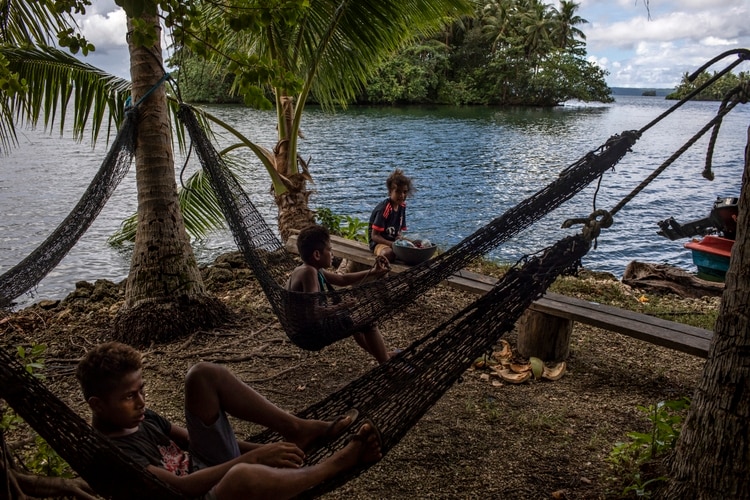 Jóvenes en la orilla del lago Tegano, el lago más grande en el Pacífico insular y parte de un sitio del Patrimonio de la Humanidad. (David Maurice Smith/The New York Times)
