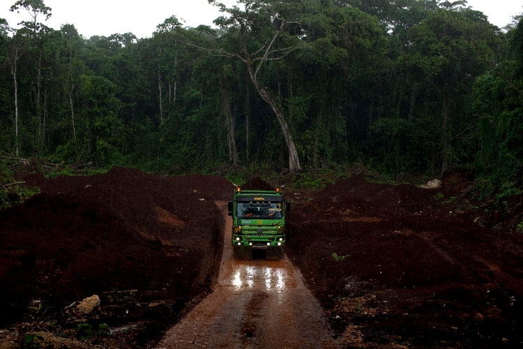 Camiones de la compañía de minería pasan a través de los poblados durante el día y la noche, para moverse a través del bosque hasta el puerto, y dejan un rastro de polvo detrás de ellos. (David Maurice Smith/The New York Times)