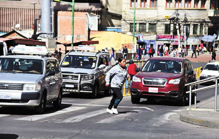 La Paz. Una persona cruza la calle Mercado mientras los vehículos avanzan, el 28.
