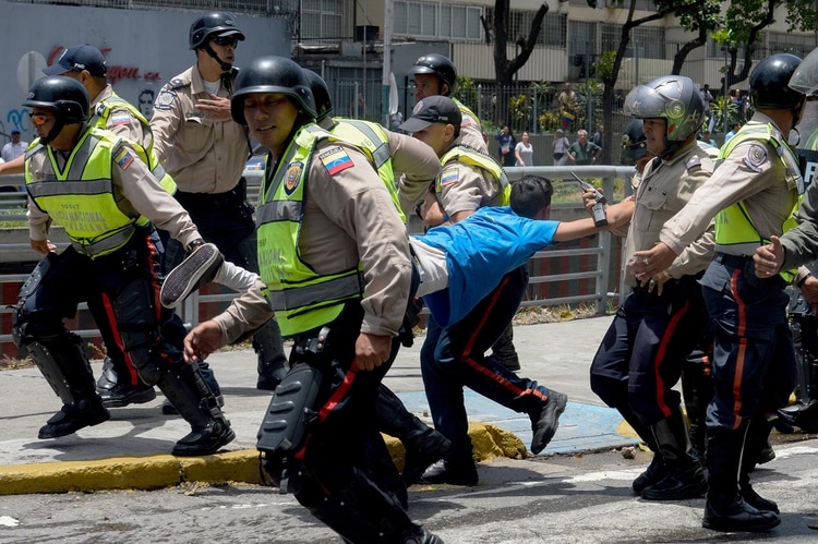 la Policía NAcional Bolivariana se lleva a un manifestante detenido (AFP)