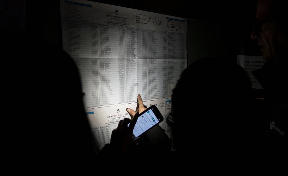 Una persona ilumina con su mÃ³vil el listado de electores asignados a una mesa de Rosario, en Santa Fe, en medio del apagÃ³n que afectÃ³ a Argentina el domingo. 