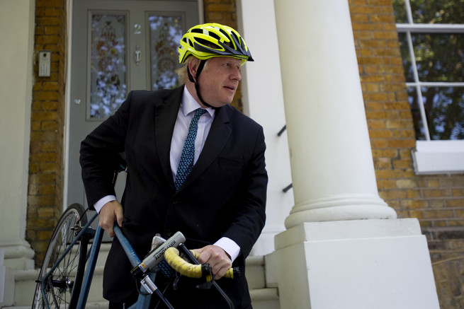 Boris Johnson saliendo de su casa con bicicleta.