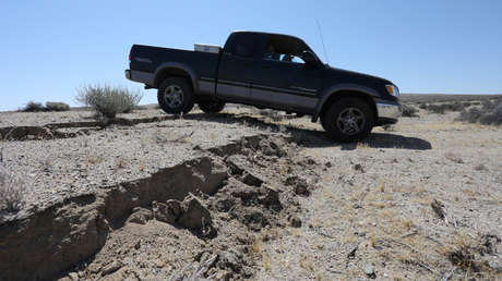 Una camioneta pasa sobre una grieta creada por un sismo al este de la ciudad de Ridgecrest, California.
