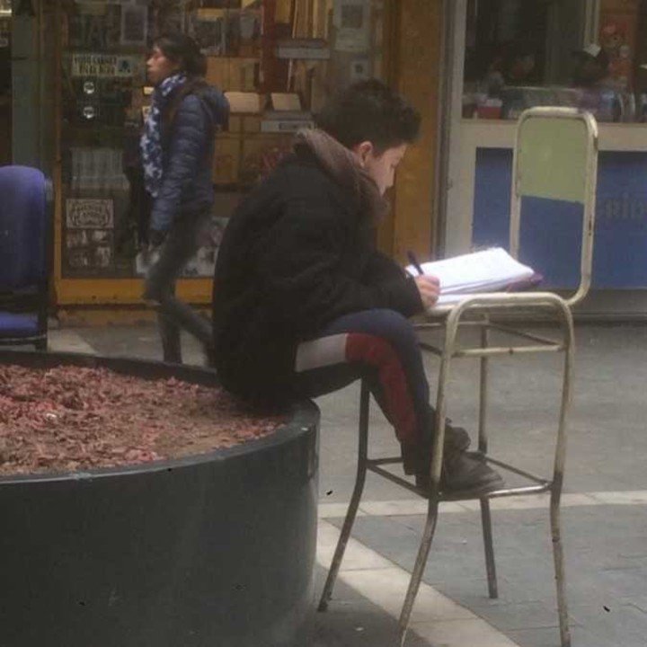 Jueves, 16.30, temperatura, 7 grados. Angelo estudia inglés, sentado en medio de la peatonal San Martín, esquina 9 de Julio. "Estoy acostumbrado, no me molestan los ruidos ni la gente".