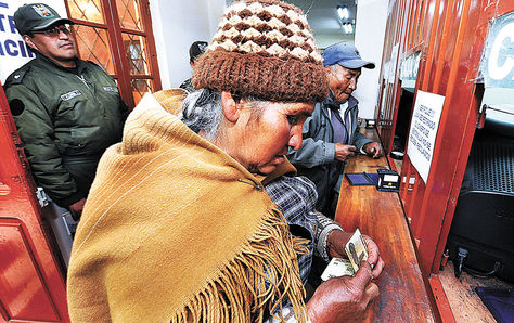 Aportes. Una mujer de la tercera edad cobra en una ventanilla su renta.