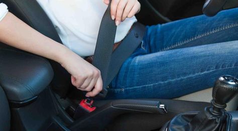 Una persona sujeta el cinturón de seguridad de su vehículo.