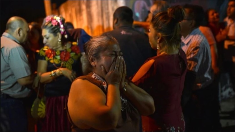 Familiares de las víctimas observan, desde el cordón policial, hacia el sitio donde un grupo armado ingreso a una fiesta y asesinó a 13 personas (Foto: EFE)