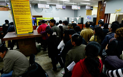 Varios personas hacen fila para el pago de sus impuestos municipales de inmuebles y vehículos. 