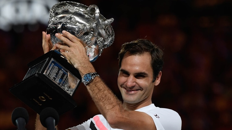 Roger Federer de Suiza tiene el trofeo de los ganadores después de vencer a Marin Cilic de Croacia en el partido final de individuales masculino el día 14 del torneo de tenis Abierto de Australia en Melbourne el 28 de enero de 2018 (AFP)