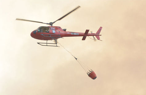 Un helicóptero se desplaza con agua. Foto: Archivo-La Razón