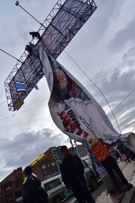 Obreros trabajan en la valla publicitaria que causó polémica.
