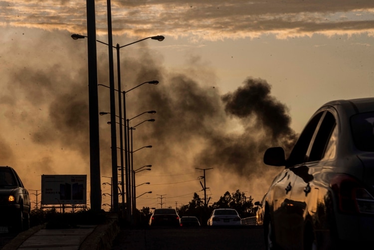 El humo de los autos incendiados se eleva en medio de un tiroteo en Culiacán, México, el jueves 17 de octubre de 2019. Un intenso tiroteo con armas pesadas y vehículos incendiados que bloqueaban las carreteras estalló en la capital del estado mexicano de Sinaloa el jueves pasado (Foto: AP/Augusto Zurita)