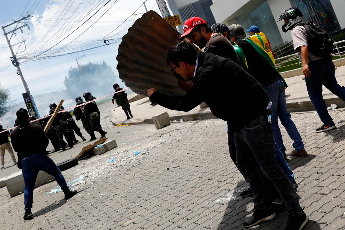 Un grupo de manifestantes se cubren ante el avance de las fuerzas de seguridad en La Paz (REUTERS/Kai Pfaffenbach)