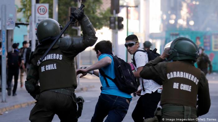 Foto de carabineros siguiendo a manifestantes en Chile