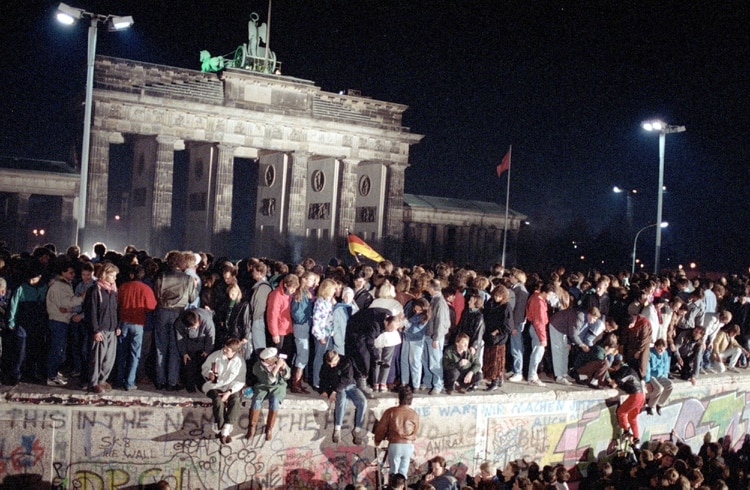 El 10 de noviembre de 1989, los ciudadanos de Alemania Oriental y Occidental celebran subidos al muro de Berlín en la puerta de Brandenburgo tras el anuncio de la apertura de la frontera de Alemania Oriental (Foto: Martti Kainulainen/Shutterstock (503486f)).