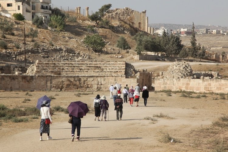 A picture taken on November 6, 2019, shows tourists walking at the ancient Jordanian Roman city of Jerash, a popular attraction 50 kms north of the capital Amman. (Photo by Ahmad ABDO / AFP)