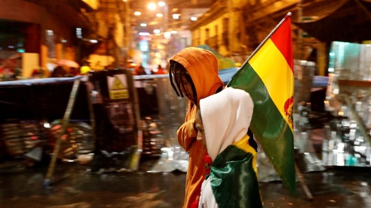 Un manifestante camina frente a una barricada en La Paz (Reuters)