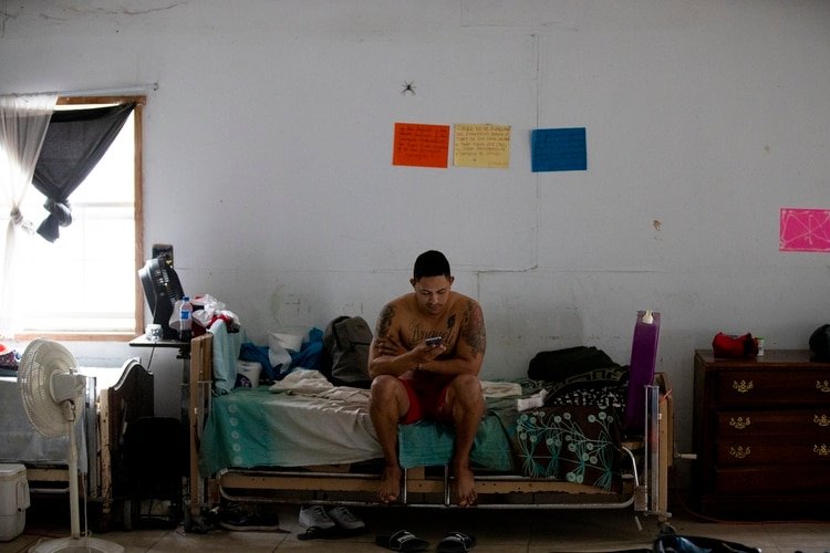En esta imagen del 12 de octubre de 2019, un migrante cubano mira su celular en un refugio para migrantes en Reynosa, México, el sábado 12 de octubre de 2019. En años anteriores, los migrantes pasaban con rapidez por esta tierra de cárteles. Ahora, con las nuevas políticas migratorias de Donald Trump, se quedan ahí durante meses mientras esperan sus citas en las cortes estadounidenses, varados en las fauces del crimen organizado. (AP Foto/Fernando Llano)