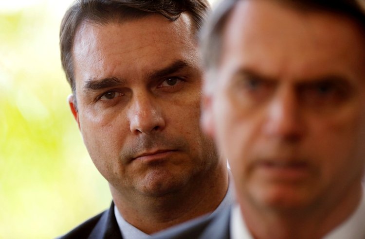 FILE PHOTO: Flavio Bolsonaro, son of Brazil's President Jair Bolsonaro, is seen behind him at the transition government building in Brasilia, Brazil November 27, 2018. REUTERS/Adriano Machado/File Photo
