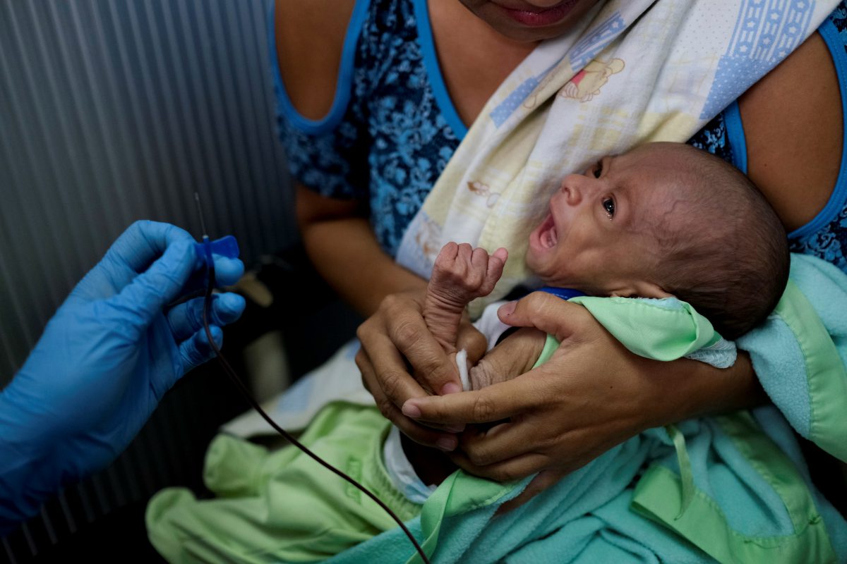 Francys Rivero sostiene a su hijo Kenai, de dos meses, a quien le diagnosticaron desnutrición, mientras le hacen un análisis de sangre en una clínica en Barquisimeto, Venezuela (REUTERS/Carlos García Rawlins)