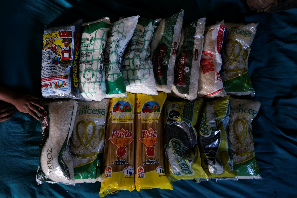 Pastor Suárez, de 3 años, que fue hospitalizado unos meses antes por desnutrición según su madre, toca los alimentos disponibles que se muestran en una cama para una foto en su casa en Barquisimeto (REUTERS/Carlos García Rawlins)