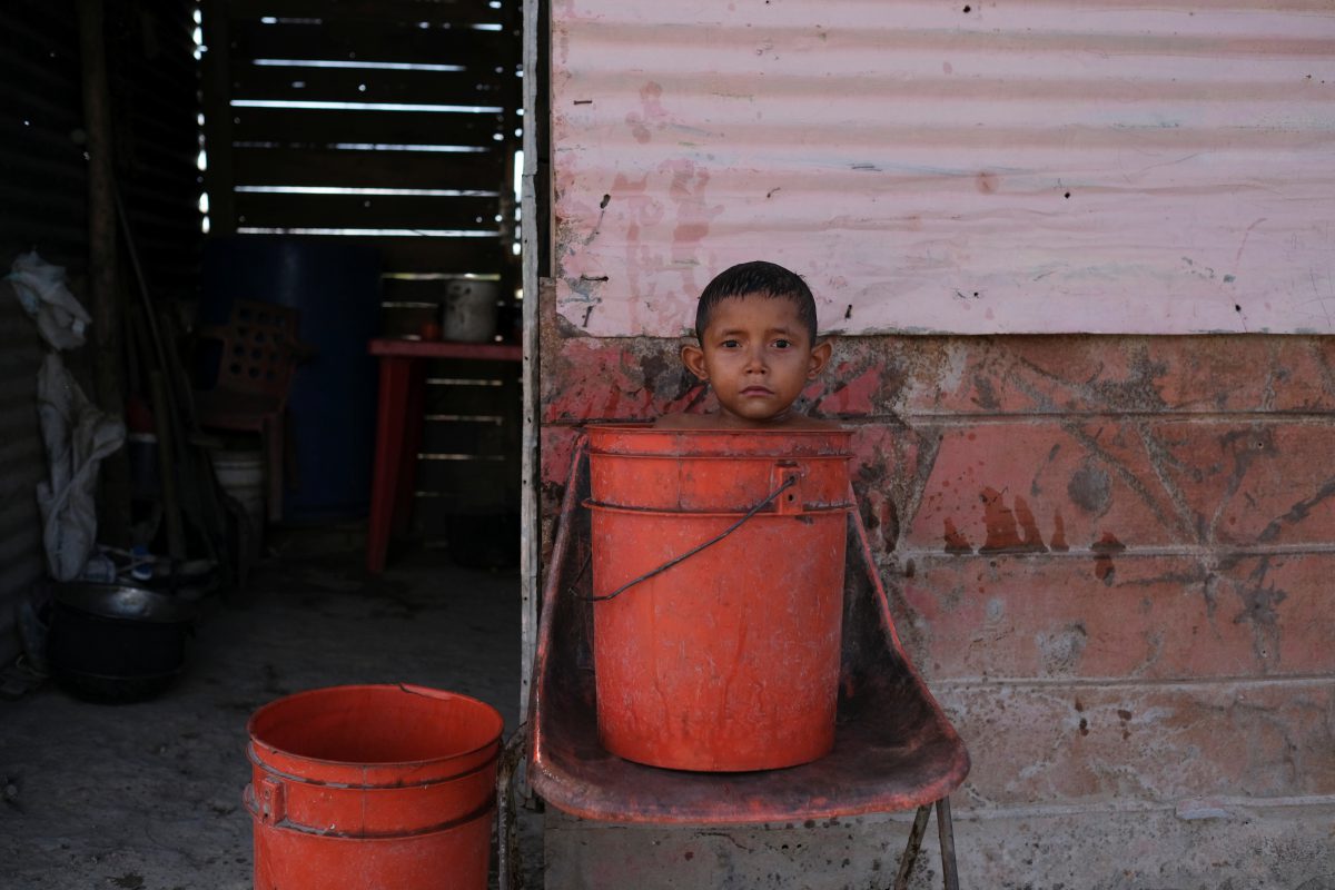 José María, de 6 años, con bajo peso para su edad y diagnosticado con desnutrición según su madre Rosa Rojas, se baña frente a su casa en Barquisimeto (REUTERS/Carlos García Rawlins)