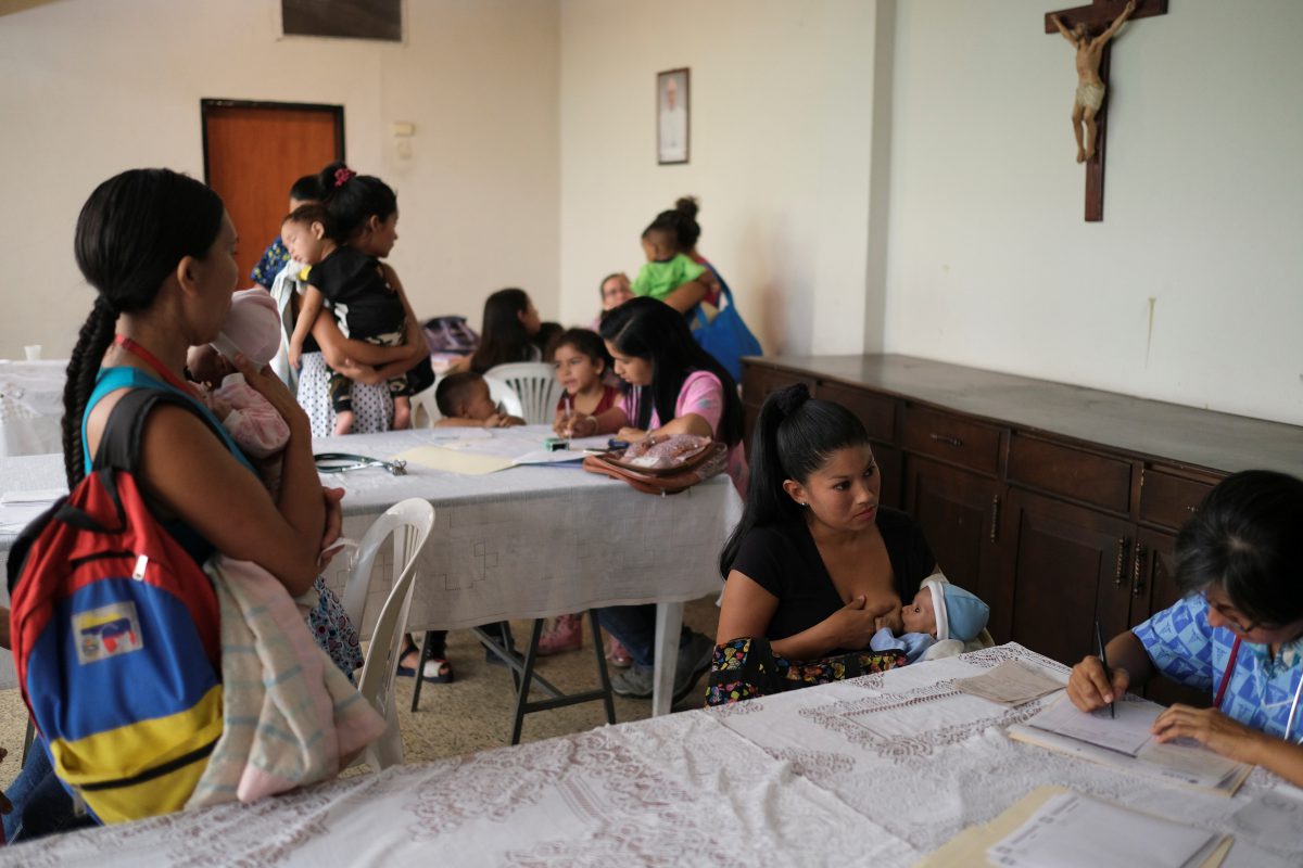 Distintas familias con niños desnutridos asisten a un encuentro en una iglesia (REUTERS/Carlos García Rawlins)
