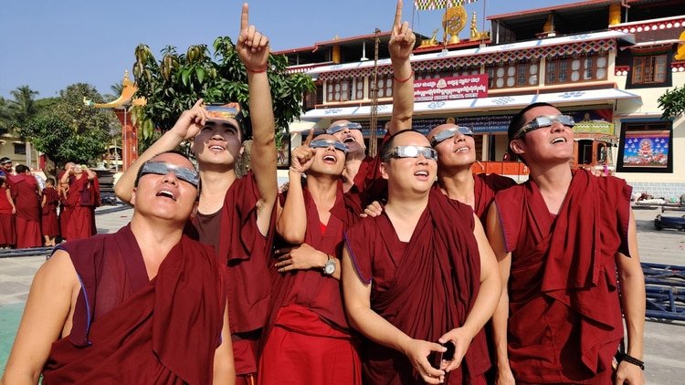 Los monjes observando el eclipse (Photo by Rakesh Nagar / AFP)