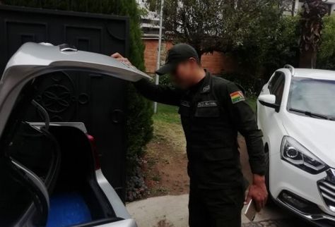 Un efectivo policial requisa un vehículo que se supone es la embajada de México.
