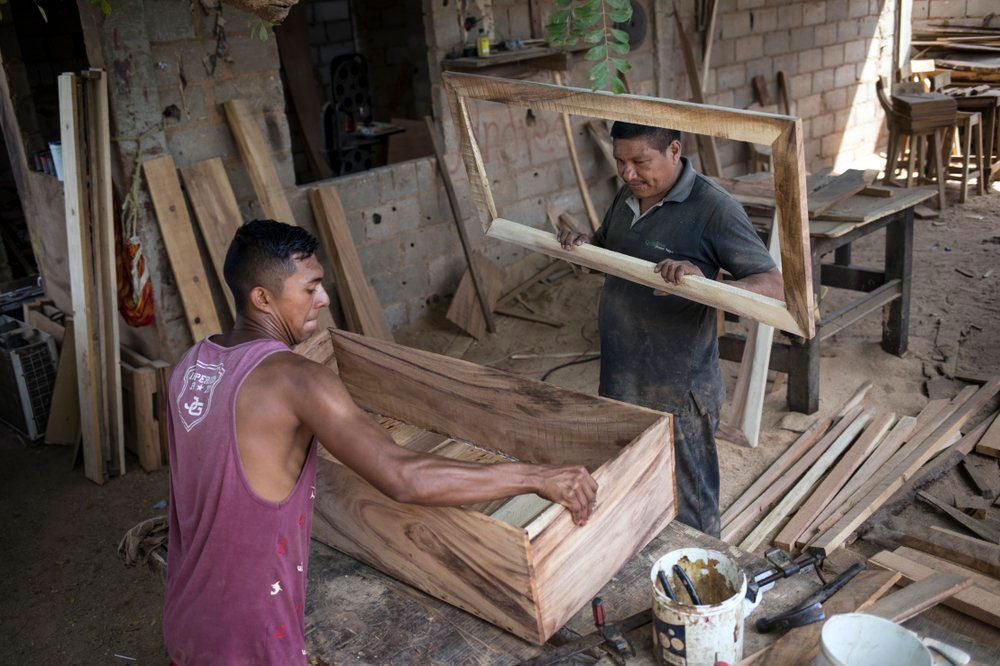 Sergio Morales, derecha, y Joelvis Cantillo, construyen un ataúd simple en su taller de muebles en Maracaibo, Venezuela, el 20 de noviembre de 2019