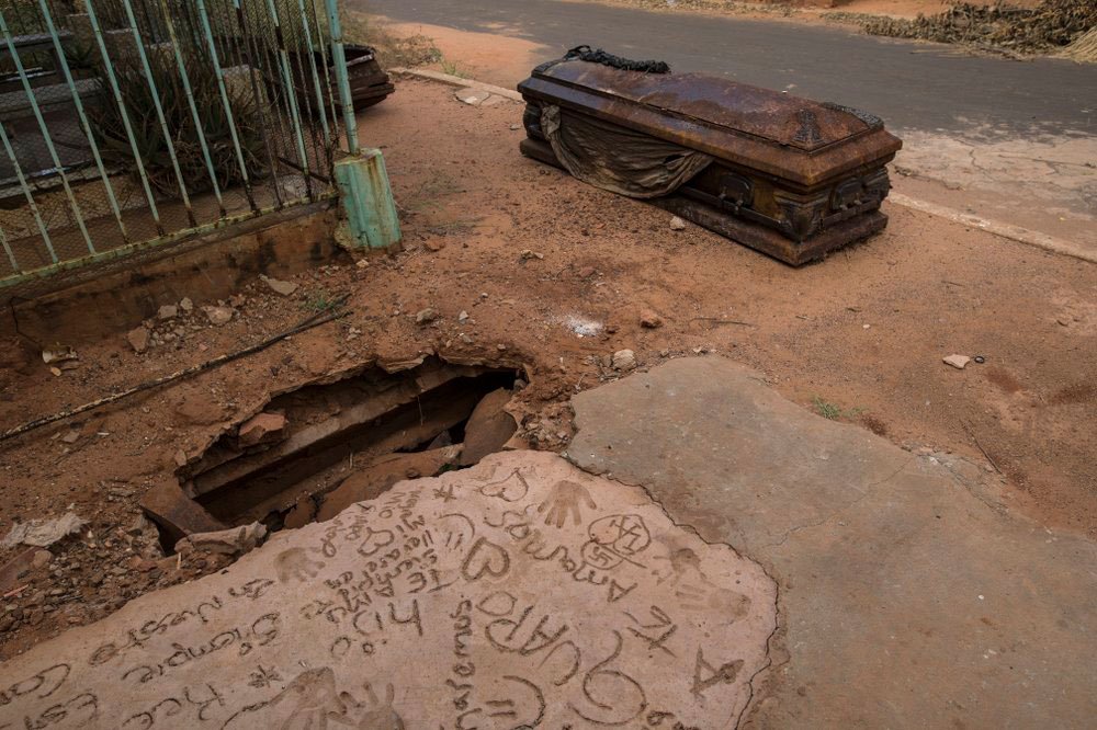 Un ataúd oxidado yace junto a una tumba excavada por ladrones en el cementerio Corazón de Jesús, en Maracaibo, Venezuela, el 21 de noviembre de 2019 (AP)