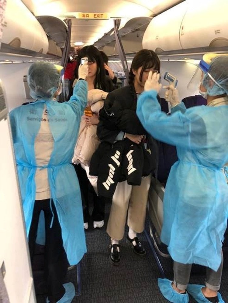 Oficiales revisan la temperatura de los pasajeros de un vuelo entre Wuhan y Macao (Reuters)