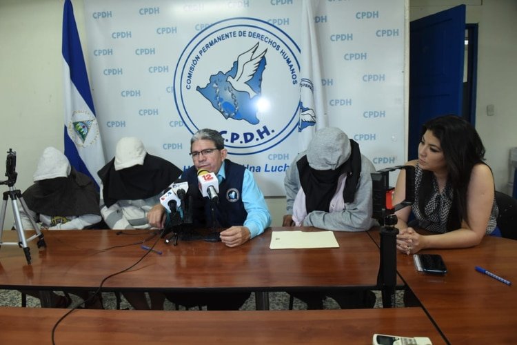 Las dos hermanas secuestradas, y su padre, dan su testimonio con el rostro cubierto por seguridad, en la Comisión Permanente de Derechos Humanos (CIDH). El abogado Pablo Cuevas les acompaña. (Foto cortesía)