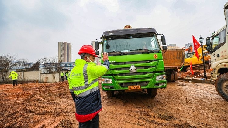Uno de los cientos de camiones que acuden a llevarse la tierra que remueven las palas mecánicas en Wuhan (Chinatopix vía AP)