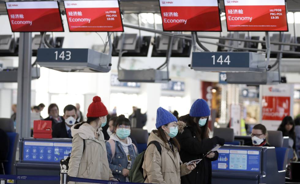 Pasajeros con máscaras en el aeropuerto de Praga, que ha comenzado una campaña de información para viajeros con posibles síntomas de coronavirus, este lunes.
