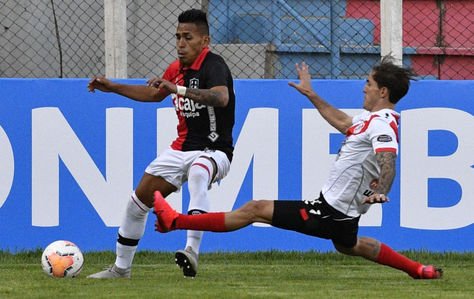 El jugador Francisco Rodríguez de Nacional Potosí disputa un balón con el mediocampista peruano Carlos Neyra.
